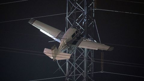 A small plane rests on live power lines after crashing Sunday, November 27, 2022, in Montgomery Village, a northern suburb of Gaithersburg, Maryland.