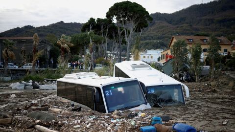 The landslide left damaged buses among the debris. 