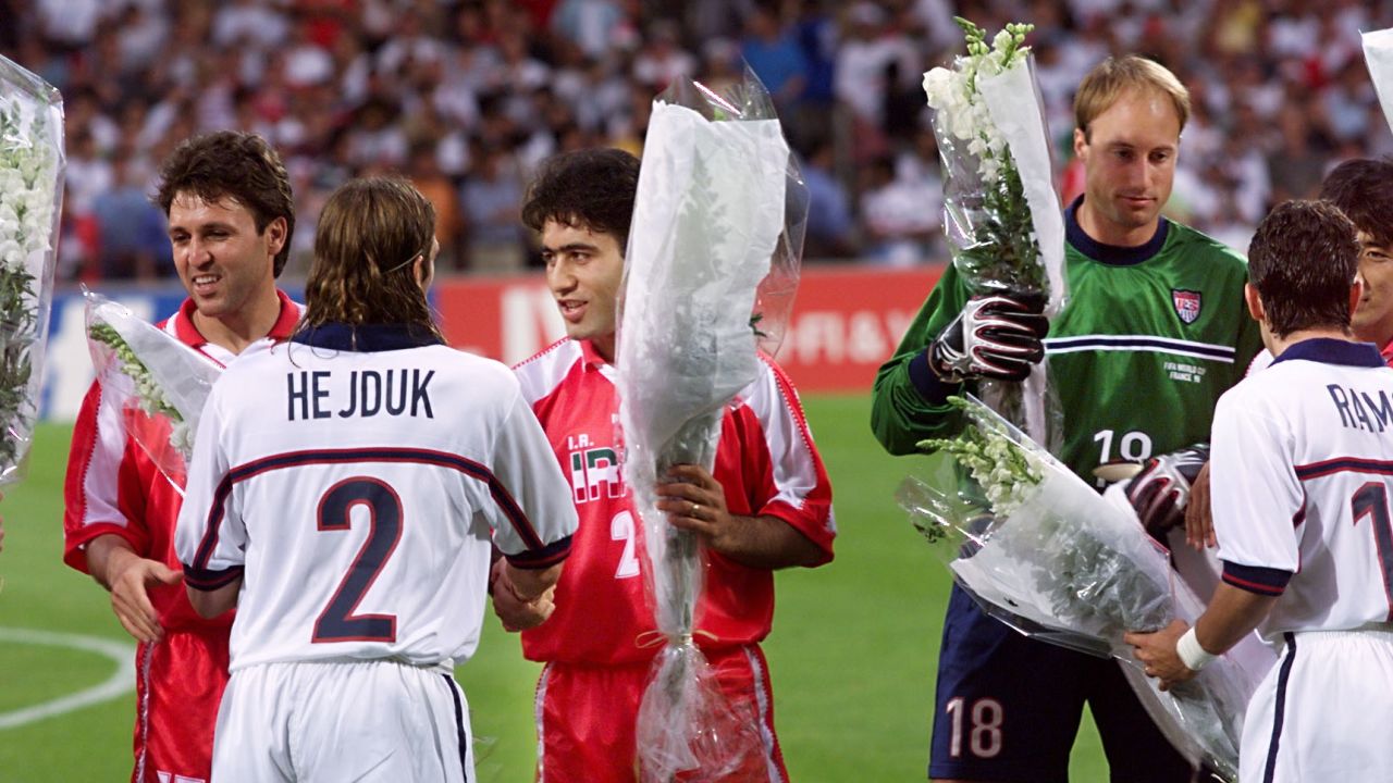 Iranian players give white roses to the US players ahead of kickoff. 