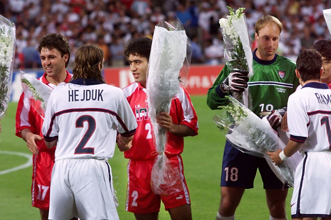 Iranian players give white roses to the US players ahead of kickoff. 