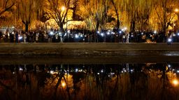 People gather for a vigil and hold white sheets of paper in protest of coronavirus disease (COVID-19) restrictions, as they commemorate the victims of a fire in Urumqi, as outbreaks of the coronavirus disease continue in Beijing, China, November 27, 2022.