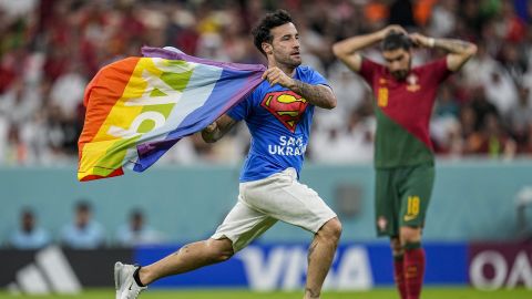 A pitch invader runs across the field with a rainbow flag during the 2022 World Cup Group H match between Portugal and Uruguay at the Lusail Stadium in Lusail, Qatar on Monday, November 28.