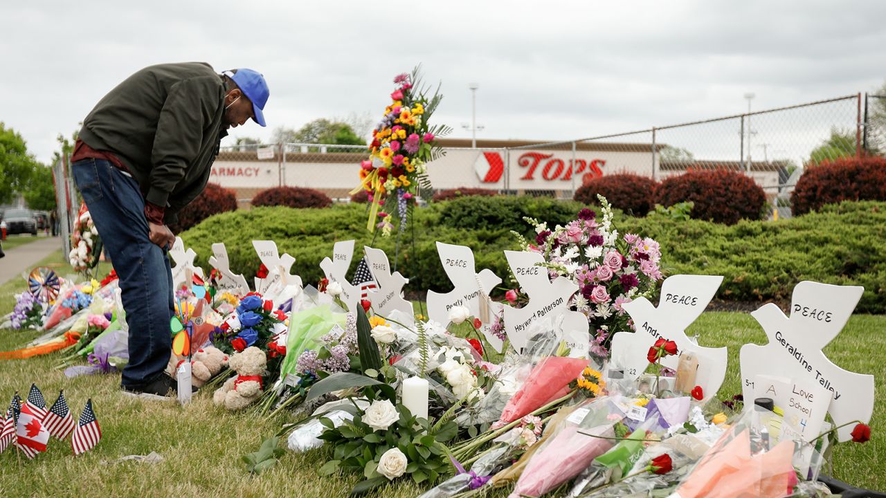 A man mourns at a memorial at the scene of a weekend shooting at a Tops supermarket in Buffalo, New York, U.S. May 20, 2022.