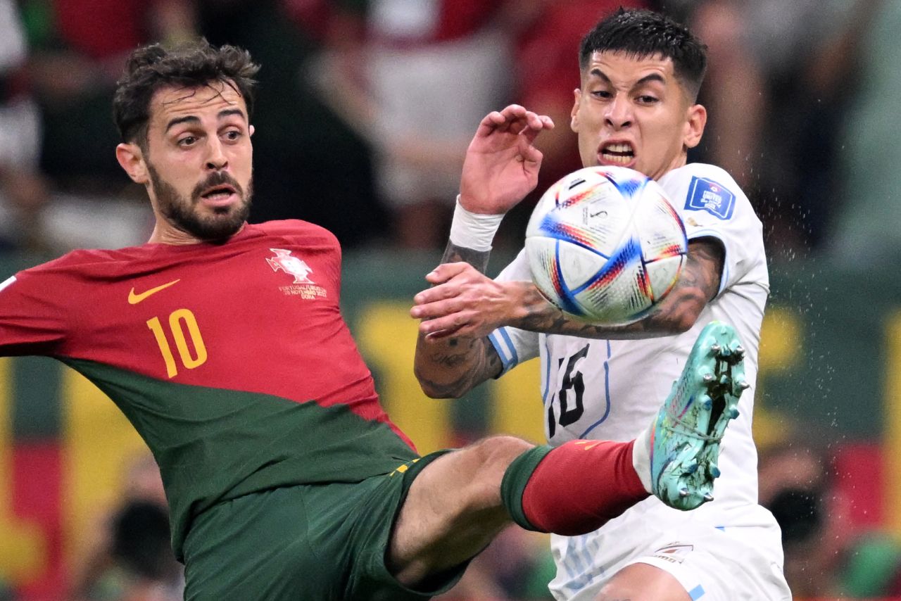 Portugal's Bernardo Silva, left, tries to keep the ball from Uruguay's Mathias Olivera.