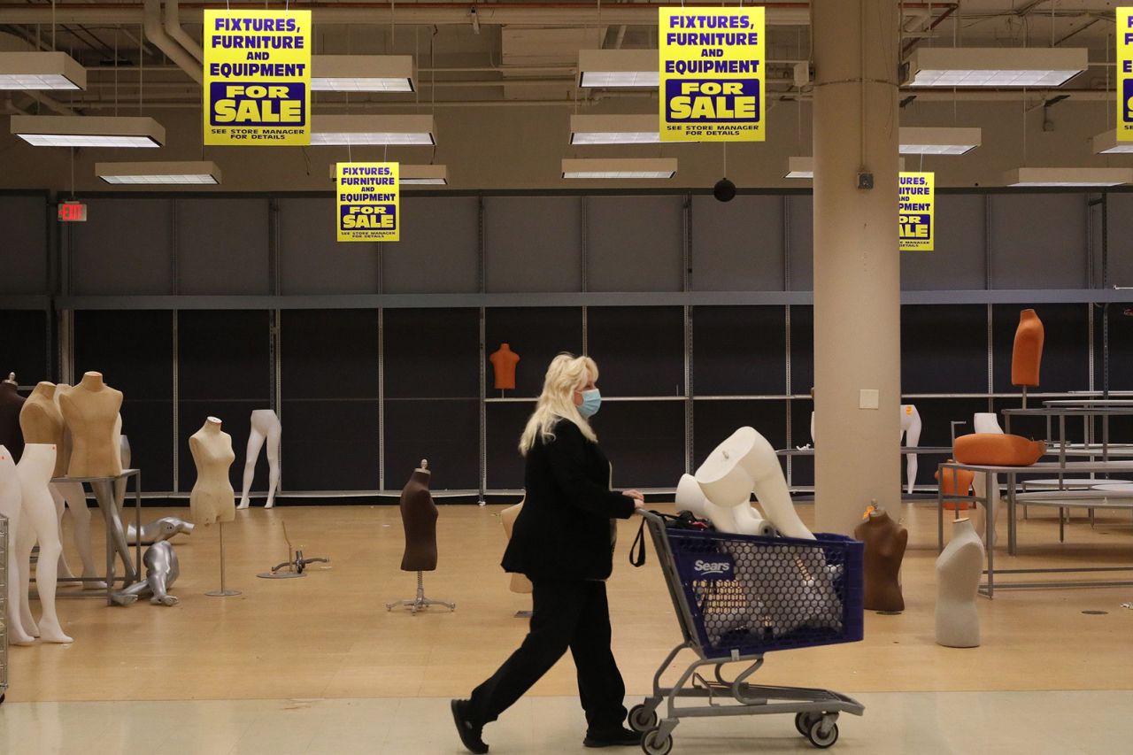 Patti Naleck pushes a cart carrying a mannequin through a Sears store that was about to permanently close in Schaumburg, Illinois, in 2021. Naleck said she plans to use the mannequin for Halloween displays. 