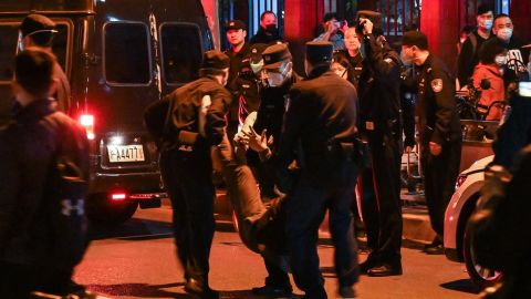 A protester is detained by police in Shanghai on Sunday night.