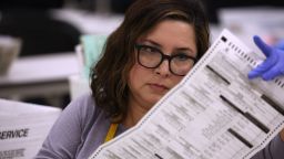 An elections worker inspects a mail-in ballot as she opens up and sorts mail-in ballots prior to tabulation at the Maricopa County Tabulation and Election Center on November 06, 2022 in Phoenix, Arizona.