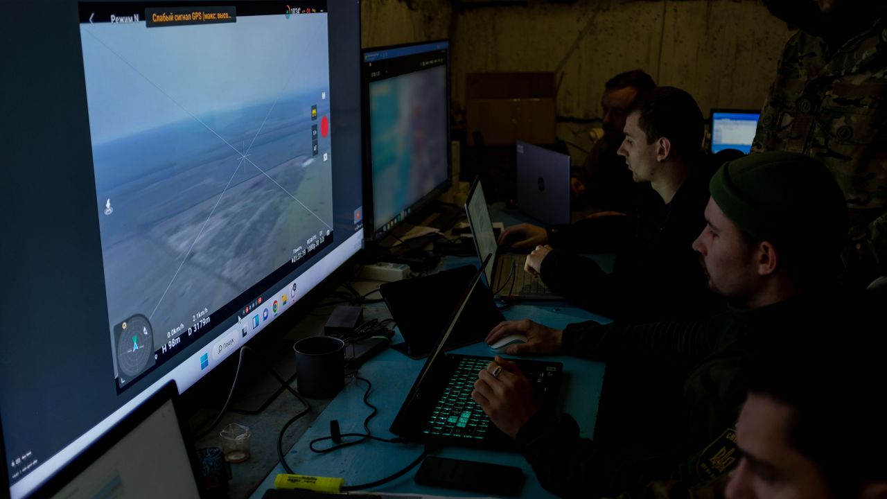 Ukrainian soldiers watch a real-time feed from a drone as they target artillery strikes on Russian positions.