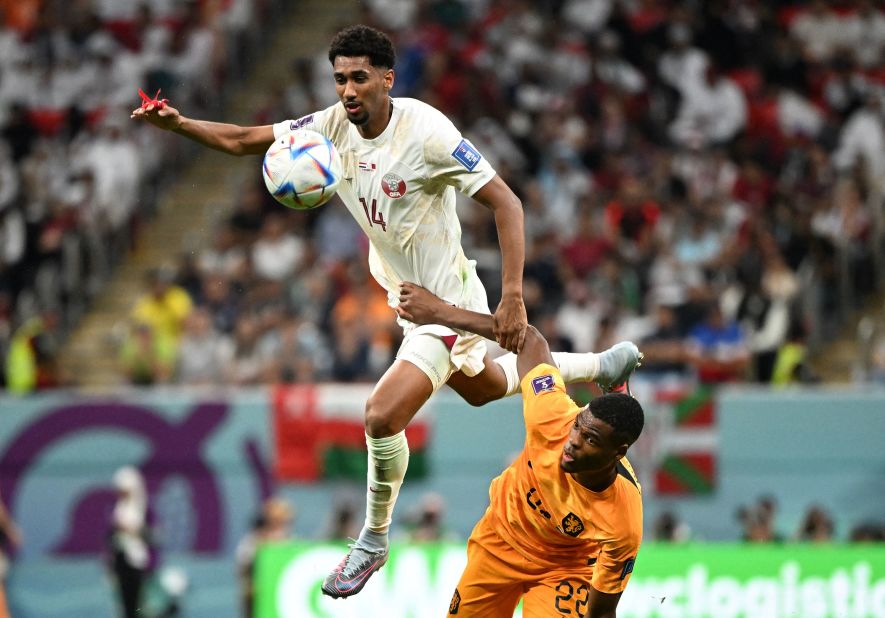 Qatar's Homam Ahmed leaps near the Netherlands' Denzel Dumfries on November 29.