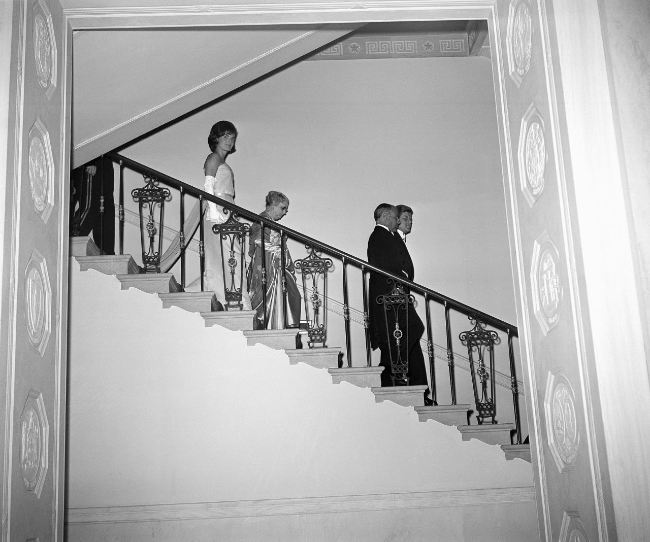 US President John F. Kennedy and Tunisian President Habib Bourguiba are trailed by their wives, Jackie and Moufida, as they walk down White House steps to pose for photos in 1961.