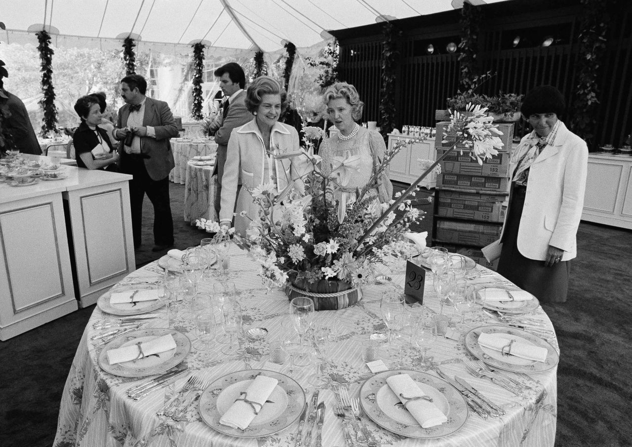 First lady Betty Ford, center left, and decorator Betty Sherrill, center right, look over table settings as they prepare for a state dinner in honor of Britain's Queen Elizabeth II in 1976.