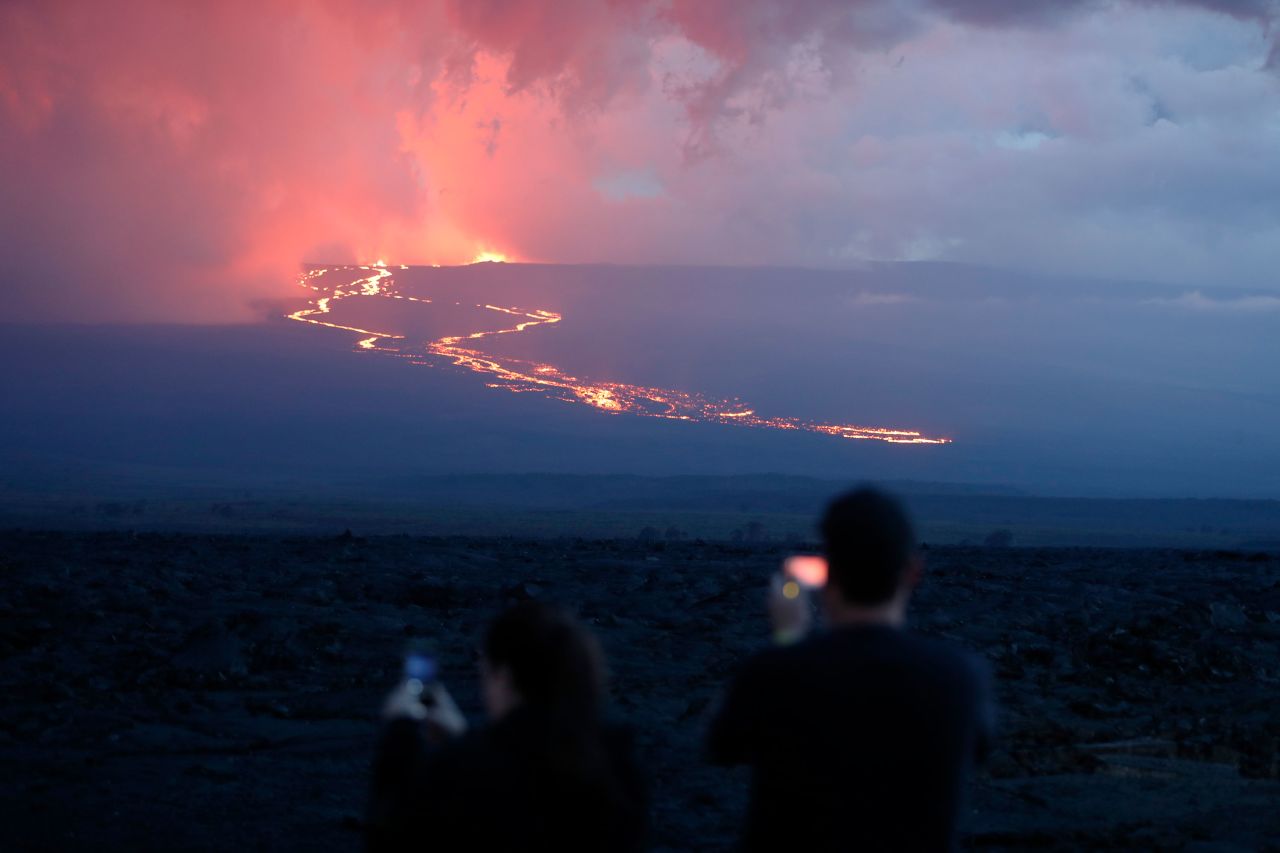 Spectators watch lava flow down the mountain near Hilo, on Tuesday, November 29.