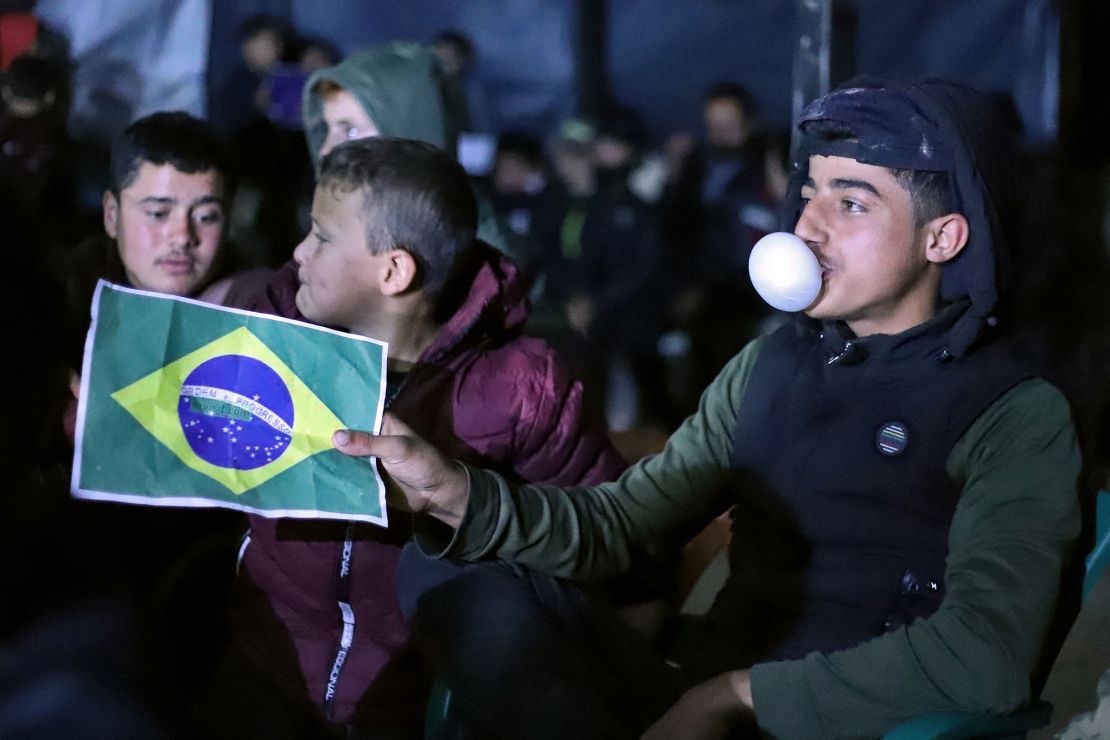 A boy shows his support for Brazil as people at the "Maram" camp for those displaced by conflict about seven kilometers from Syria's rebel-held northwestern city of Idlib watch the World Cup match between Brazil and Switzerland on Monday. 