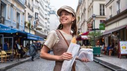 Attractive girl with French baguette on the street in Paris