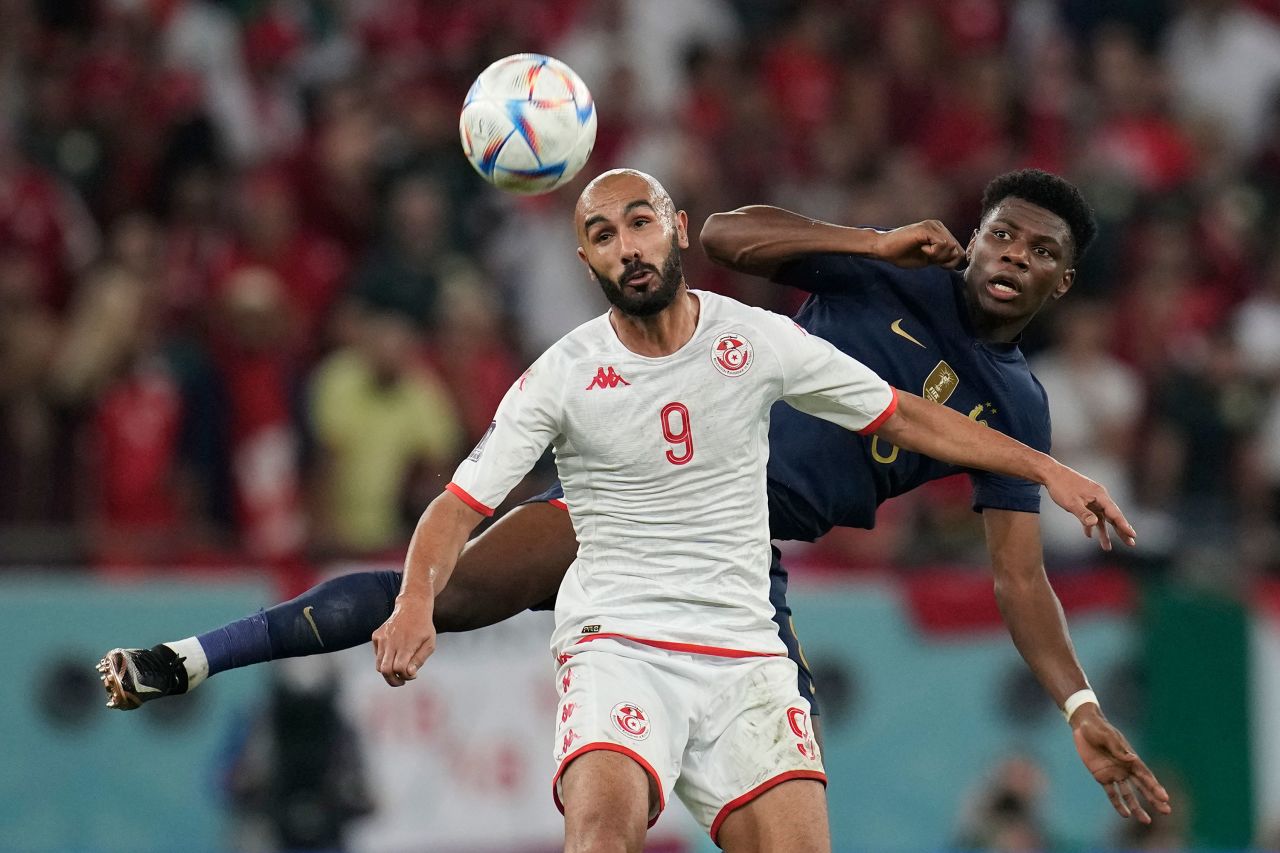 Tunisia's Issam Jebali heads the ball next to France's Aurélien Tchouaméni.