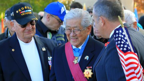 People stand to applaud Medal of Honor recipient Hiroshi Miyamura, center, during a Veterans Memorial in Albuquerque, New Mexico, on November 11, 2014.