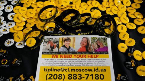 Un dépliant demandant des informations sur le meurtre de quatre étudiants de l'Université de l'Idaho est affiché sur une table avec des boutons et des bracelets lors d'une veillée mercredi à la mémoire des victimes à Moscou, Idaho. 