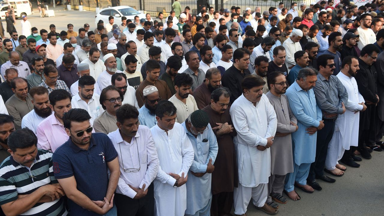 Mourners offer absentia funeral prayers in Karachi on October 27, 2022, for  Sharif. 