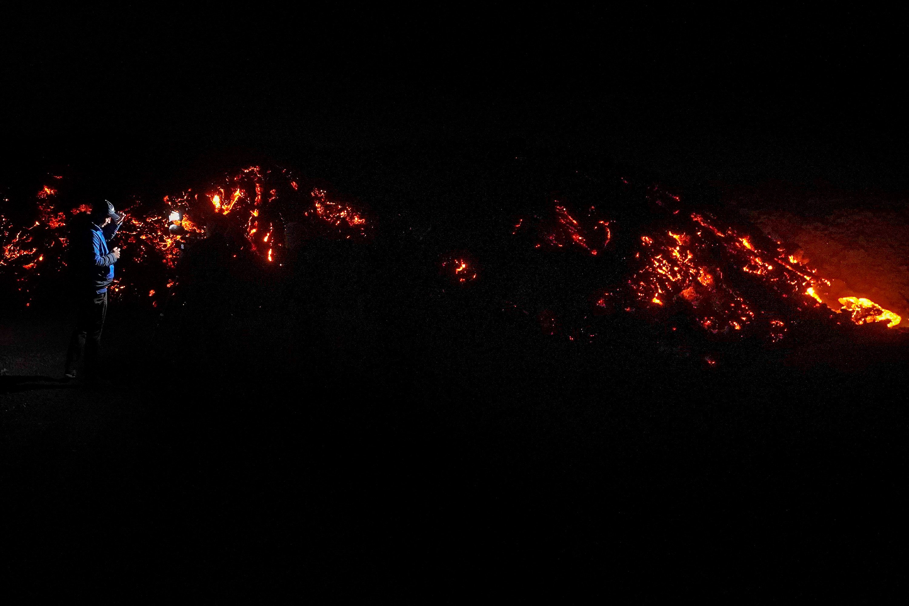 A journalist records lava from Mauna Loa.