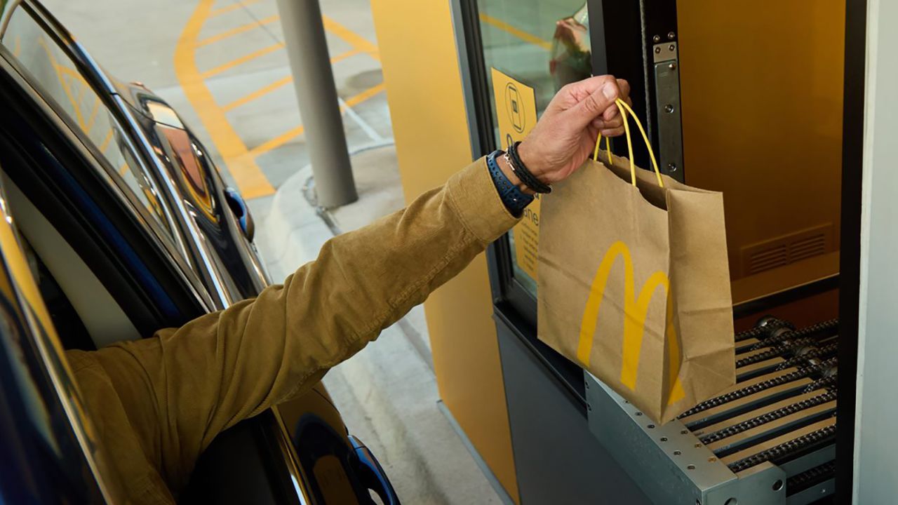 A customer picks up a McDonald's order from a conveyor.