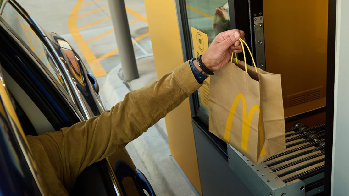 A customer picks up a McDonald's order from a conveyor.