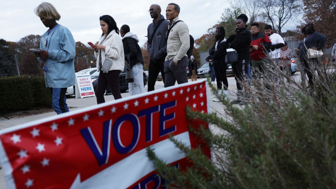 Early voters wait in line outside a polling station in Atlanta on November 29, 2022. 