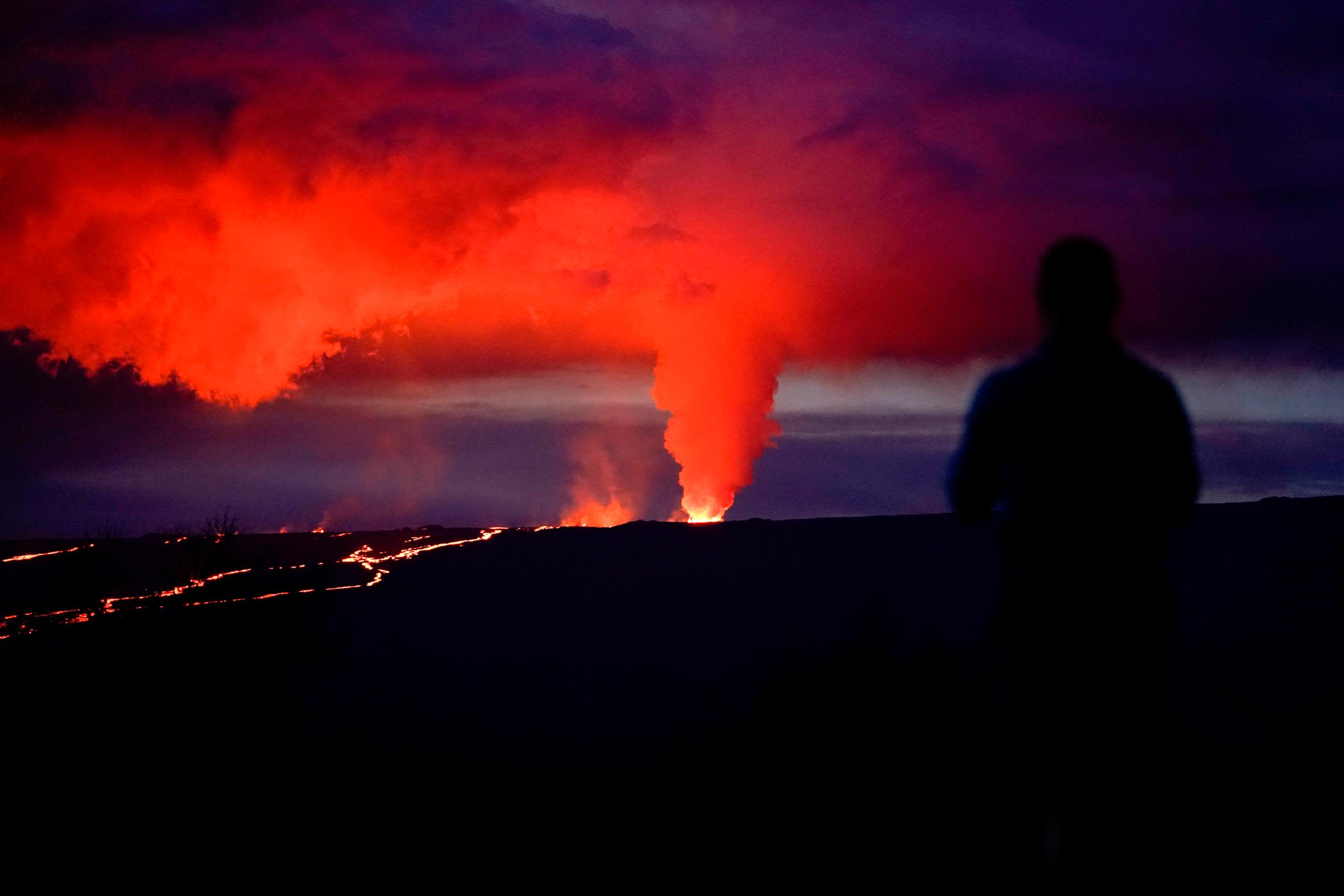 A man looks on as lava erupts from Mauna Loa on November 30.