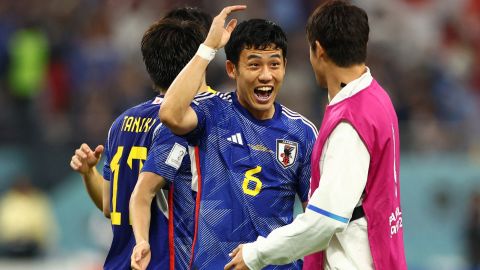 Wataru Endo celebrates with teammates after Japan reached the knockout stages of the World Cup. 