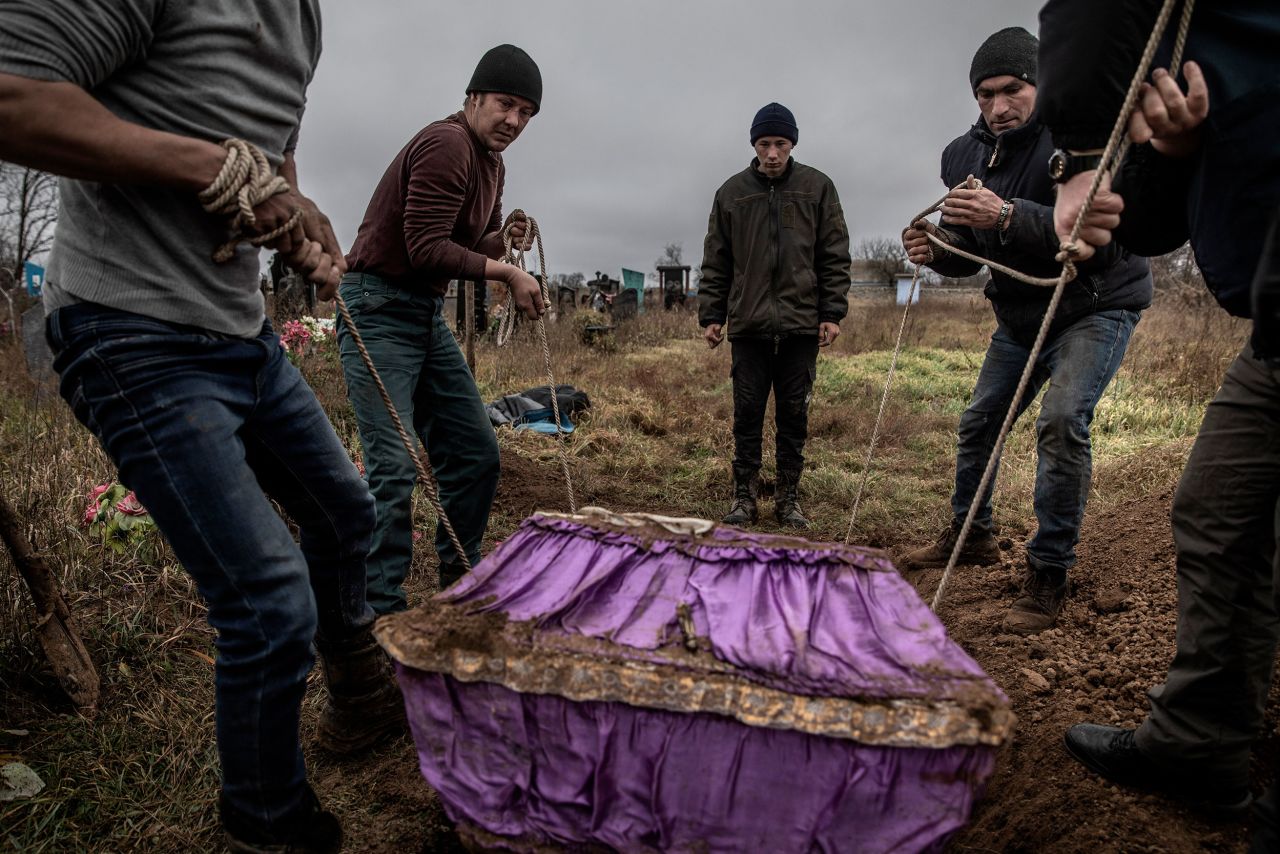 Local residents help police and war crimes investigators exhume the body of a 15-year-old girl in Pravdyne, Ukraine, on Tuesday, November 29. Residents said the girl had been executed by Russian forces along with several men whose bodies had been exhumed the day before in the recently liberated village.