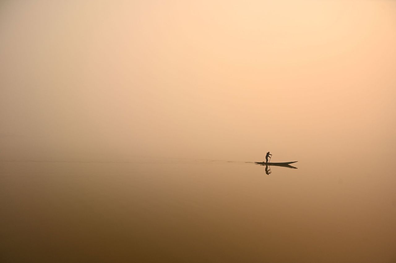 A man steers a boat in Dal Lake amid a thick blanket of fog in Srinagar, India, on Tuesday, November 29.