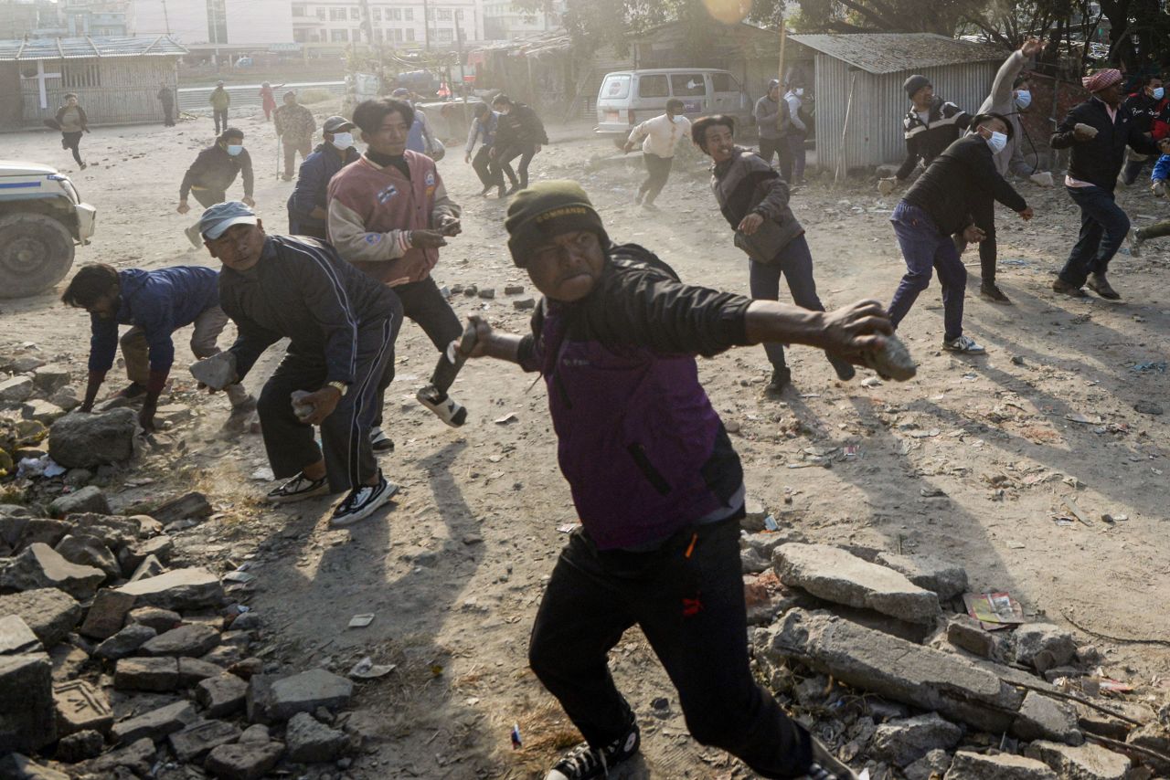 People chant anti-government slogans and hurl stones at police in Kathmandu, Nepal, as they protest the authorities' decision to remove landless squatters residing in various parts of the city.