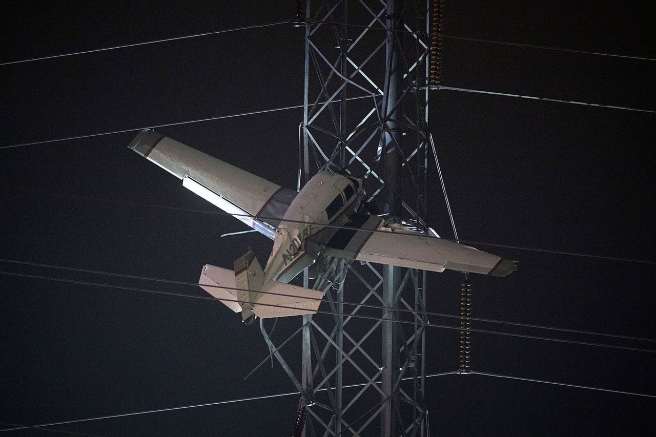 A small plane rests on live power lines after <a href=