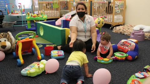 Teacher Graciela Olague-Barrios works with infants in 2021 at Cuidando Los Ninos in Albuquerque, New Mexico.