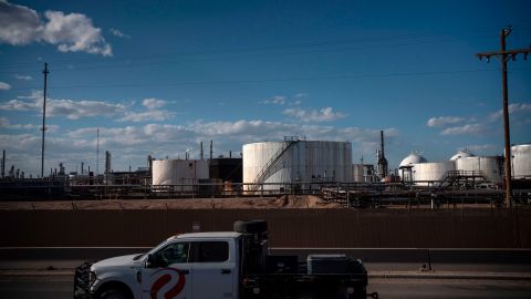 A truck drives past oil storage tanks in Artesia, New Mexico, in 2020.