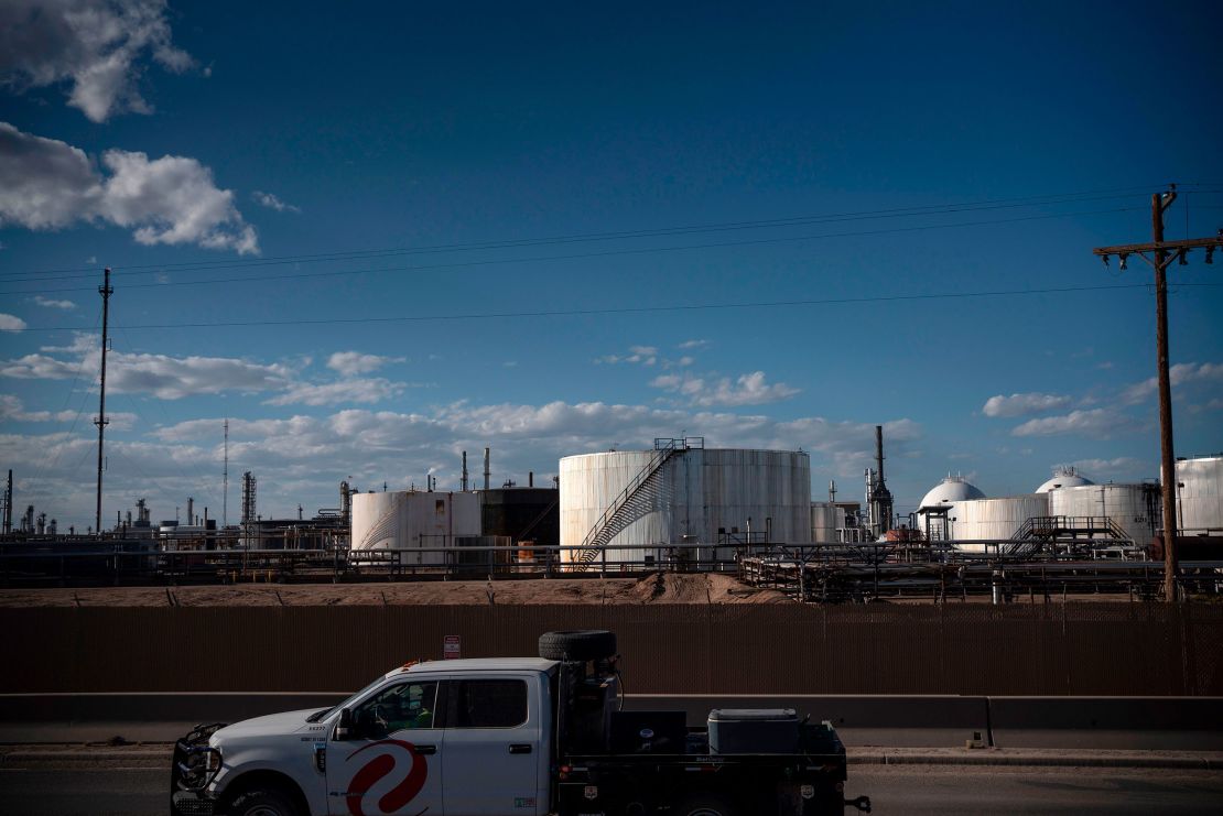 A truck drives past oil storage tanks in 2020 in Artesia, New Mexico.