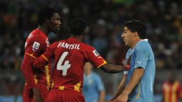 Ghana's defender John Paintsil (C) steps in between Ghana's defender Isaac Vorsah (L) and Uruguay's striker Luis Suarez (R) during the 2010 World Cup quarter-final football match between Uruguay and Ghana on July 2, 2010 at Soccer City stadium in Soweto, in suburban Johannesburg.      NO PUSH TO MOBILE / MOBILE USE SOLELY WITHIN EDITORIAL ARTICLE      AFP PHOTO / ROBERTO SCHMIDT (Photo by Roberto SCHMIDT / AFP) (Photo by ROBERTO SCHMIDT/AFP via Getty Images)