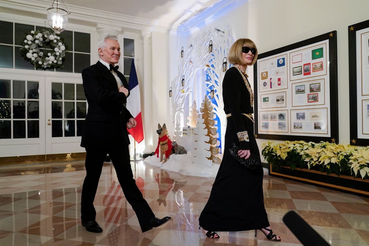 Vogue editor-in-chief Anna Wintour is accompanied by film director Baz Luhrmann.