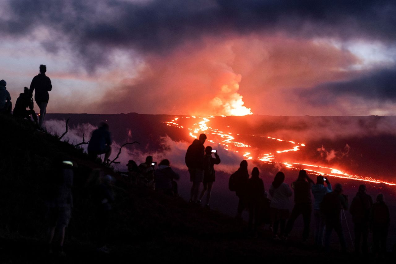 People watch lava erupt from the Mauna Loa volcano in Hawaii on Thursday, December 1.