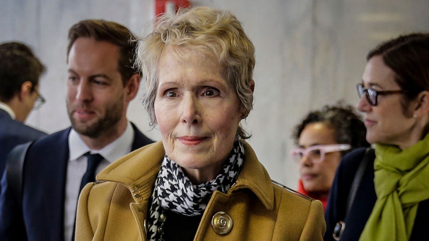E. Jean Carroll, center, waits to enter a courtroom in New York for her defamation lawsuit against President Donald Trump, March 4, 2020. 