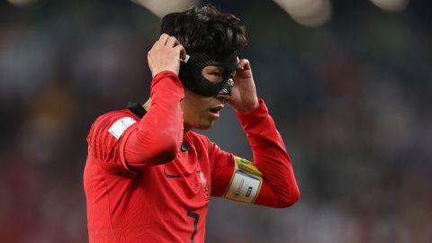 Son Heung-min adjusts his mask during South Korea's game against Portugal at the 2022 World Cup.