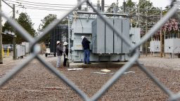 Duke Energy workers inspect a transformer radiator that they said was damaged by gunfire in Carthage, North Carolina on December 4, 2022. 