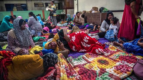 People take shelter at a community hall in Candipuro village following Mount Semeru's volcanic eruption in Lumajang, East Java on December 4, 2022.