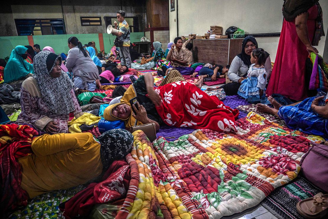 People take shelter at a community hall in Candipuro village following Mount Semeru's volcanic eruption in Lumajang, East Java on December 4, 2022.