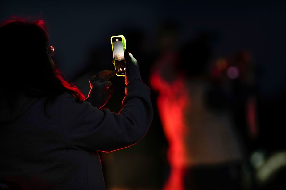 A woman records the volcano with her phone on December 3.