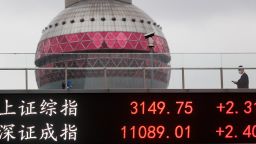 People walk on a pedestrian bridge which displays the numbers for the Shanghai Shenzhen stock indexes on November 29, 2022 in Shanghai, China. 