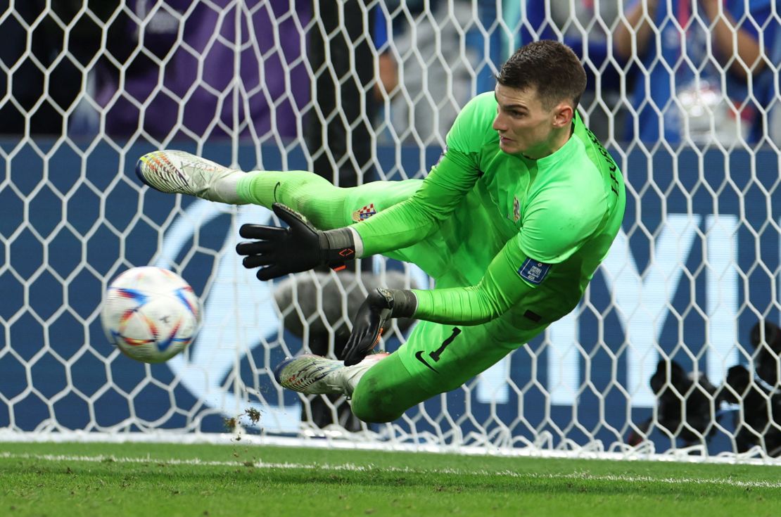 Livaković saves Takumi Minamino's effort during the penalty shootout. 