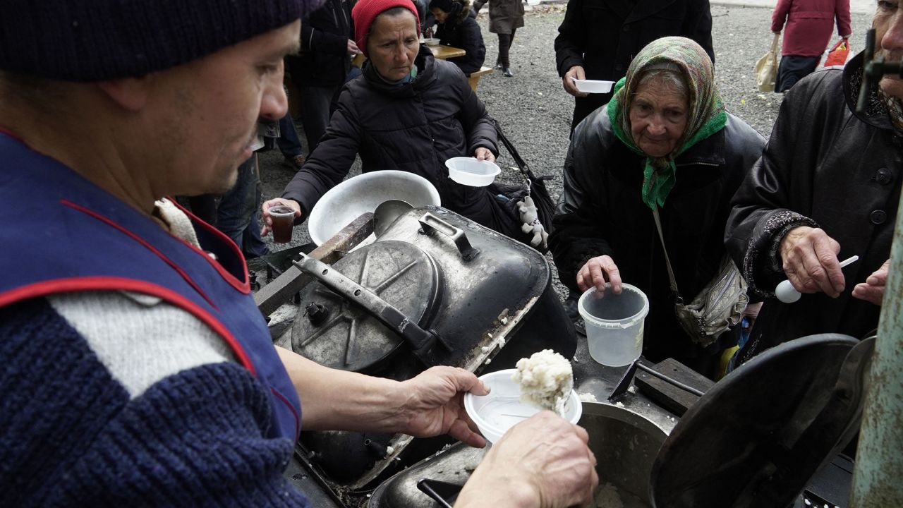 Residents receive hot meals in the port city of Mariupol in southeastern Ukraine on October 27, 2022. 