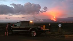 People stand on the side of the road to photograph the eruption of the Mauna Loa volcano on December 04, 2022 near Hilo, Hawaii. For the first time in nearly 40 years, the Mauna Loa volcano, the largest active volcano in the world, has erupted. 