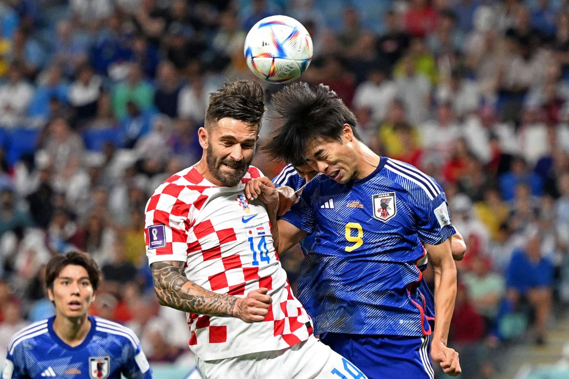 Croatia's forward #14 Marko Livaja fights for the header with Japan's forward #09 Kaoru Mitoma.