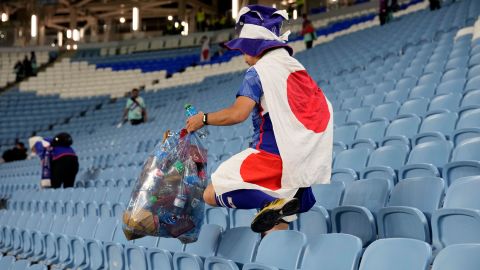 A fan of Japan collects garbage at the end of the World Cup match against Croatia at the Al Janoub Stadium in Al Wakrah, Qatar.